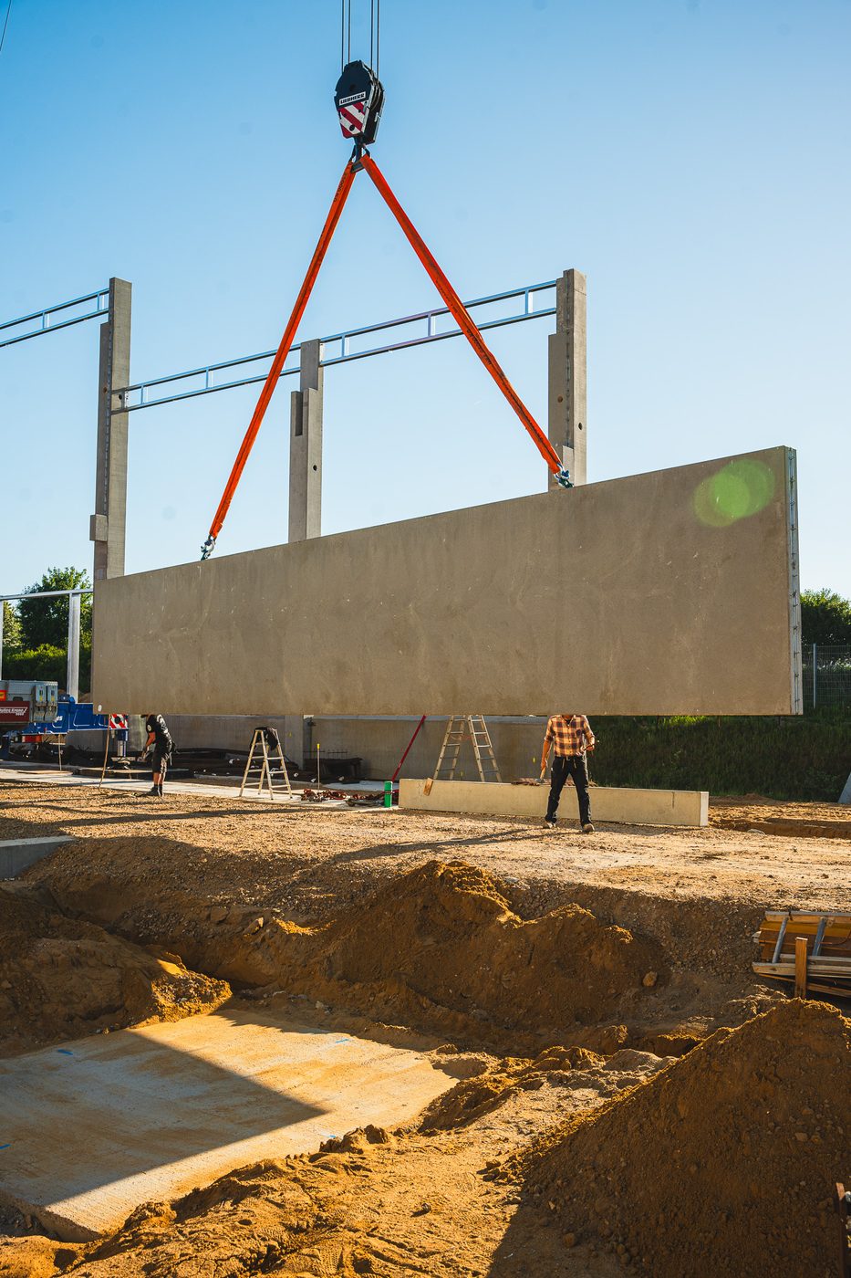Betonfertigteil wird am Kran versetzt – Rohbau der Meierei Viöl